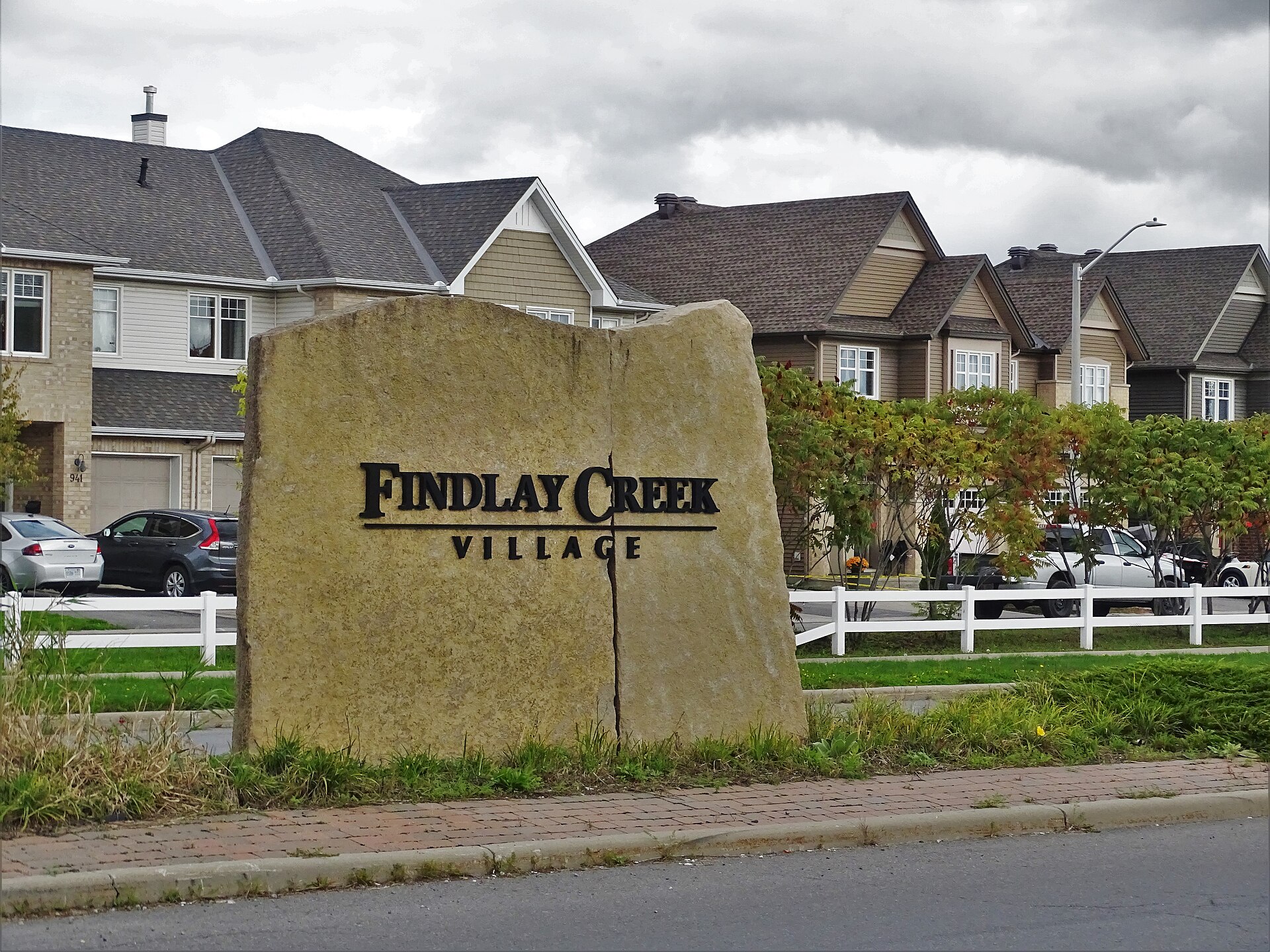 The Findlay Creek Village entrance sign with homes behind it